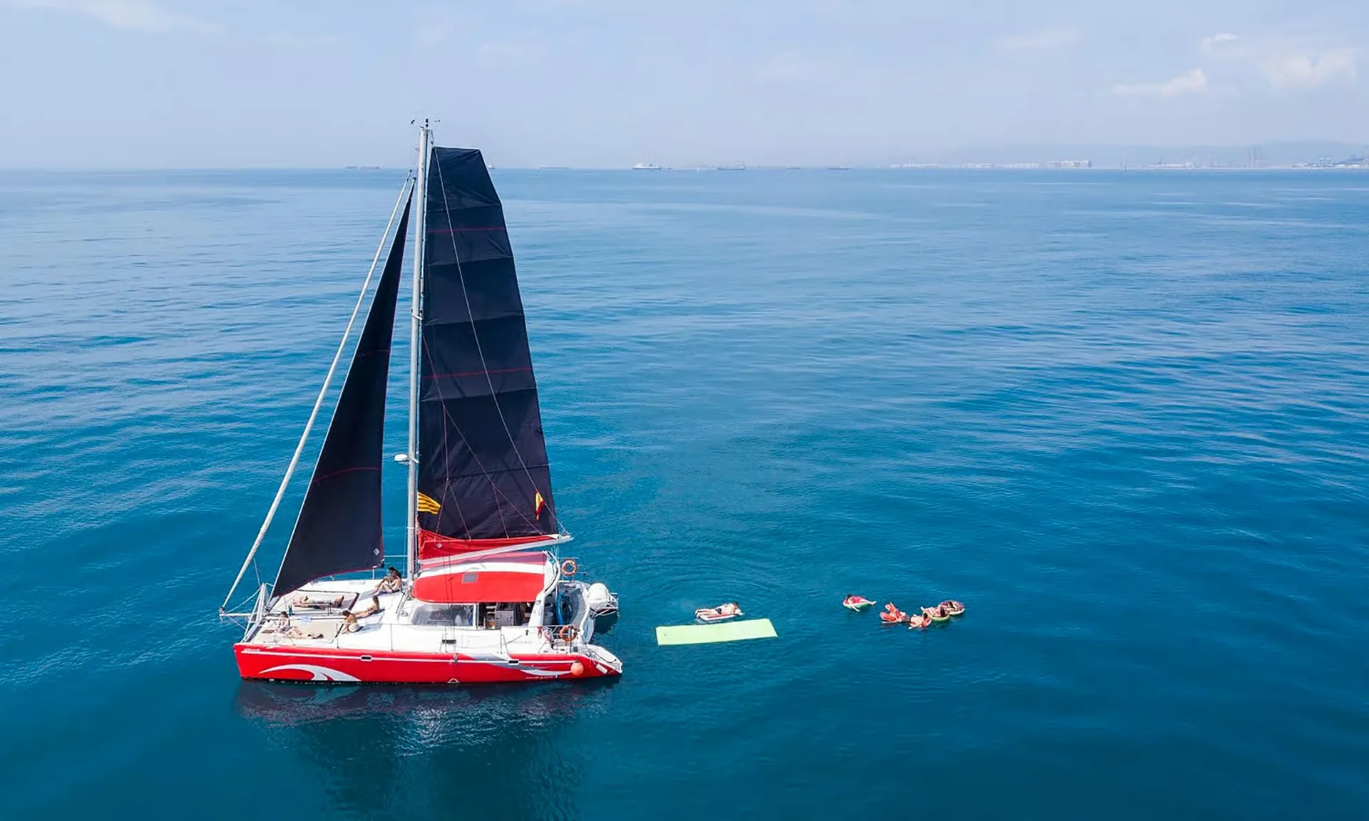Barcelona: sunset or daytime catamaran cruise with tapa and drink