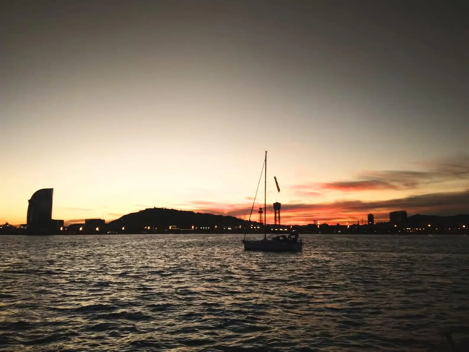 Sail along Barcelona at sunset with tapas and drinks included
